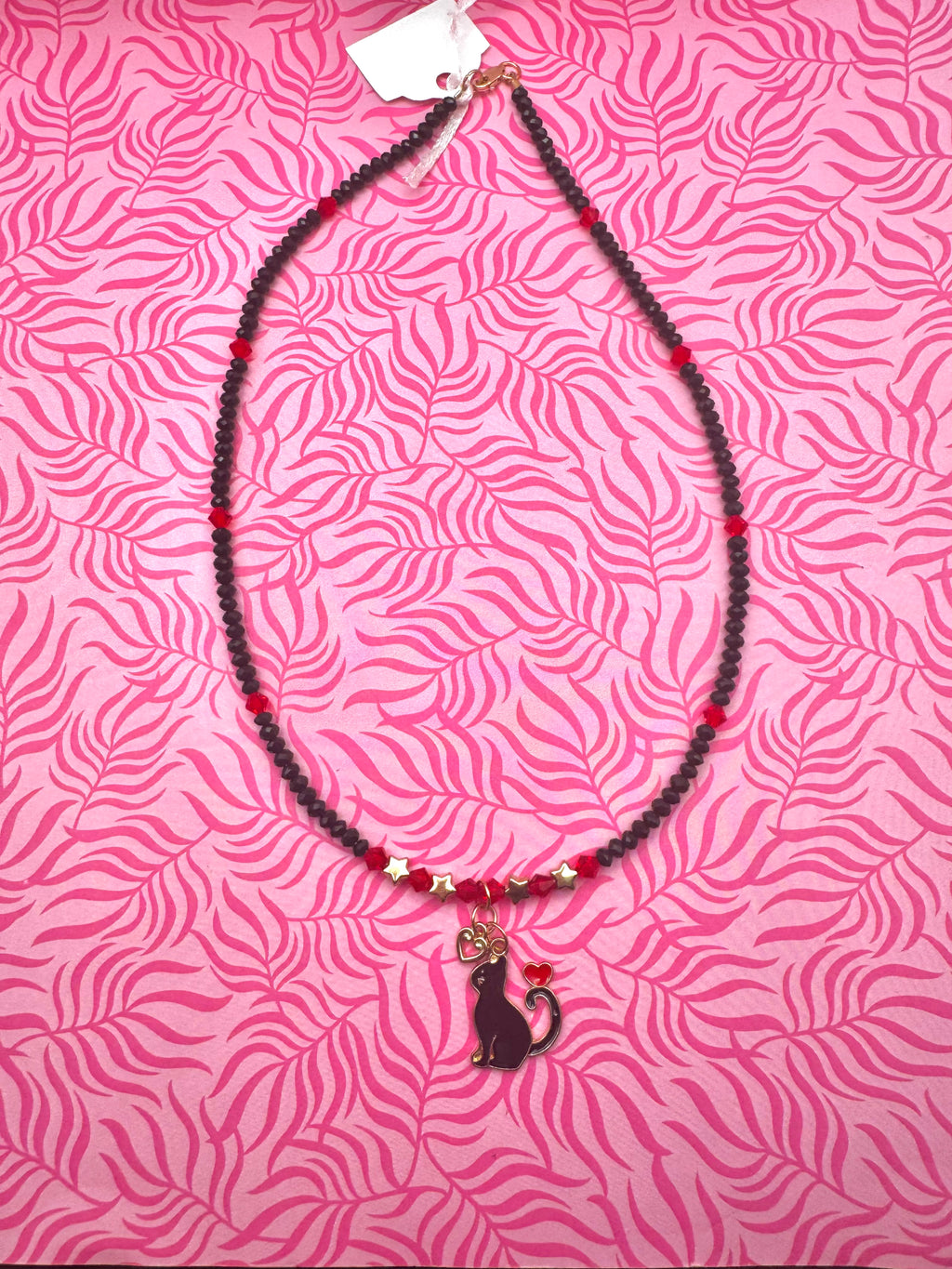 Collar hecho a mano con diseño de gatito enamorado en rojo y negro.