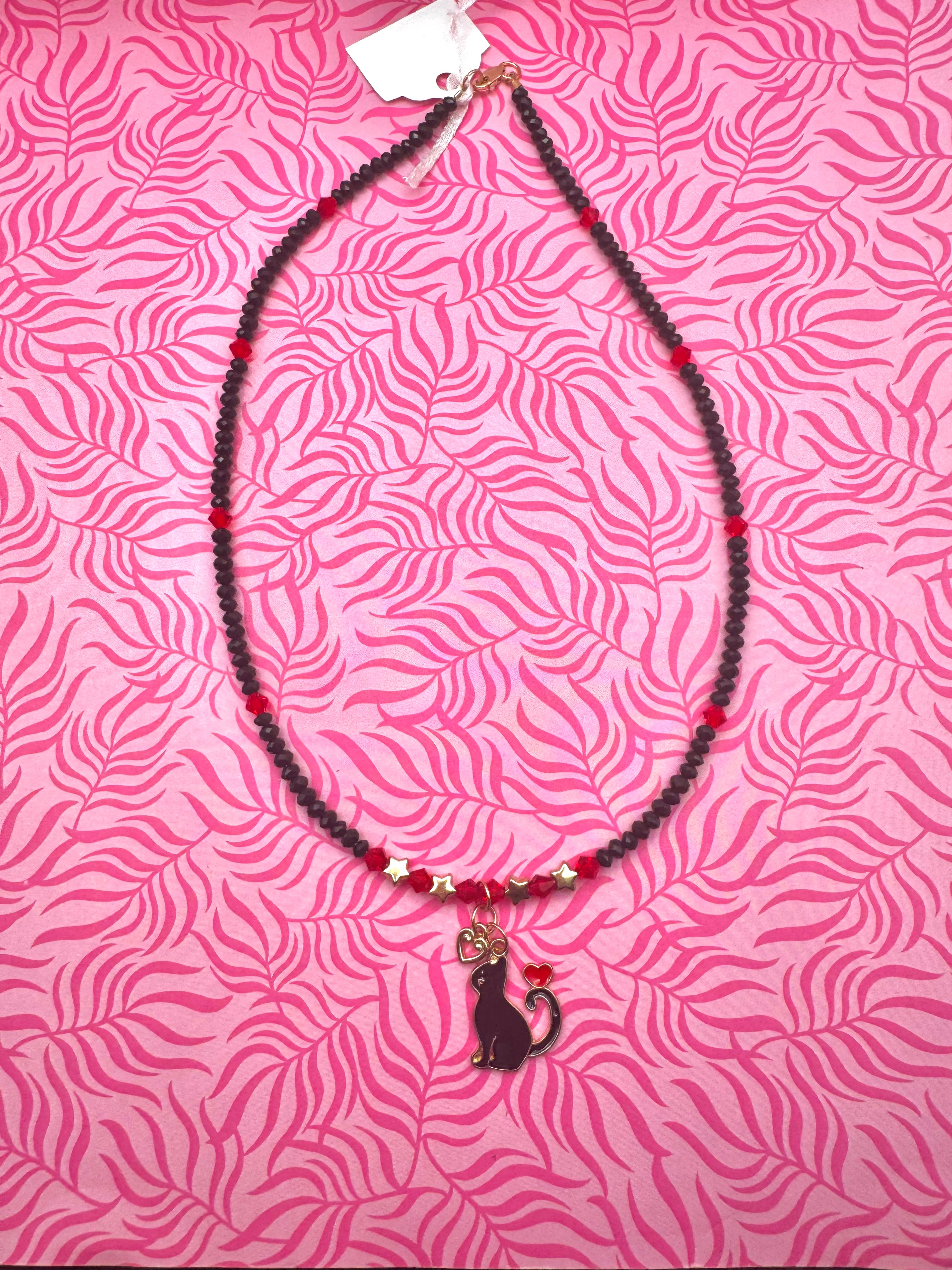 Collar hecho a mano con diseño de gatito enamorado en rojo y negro.