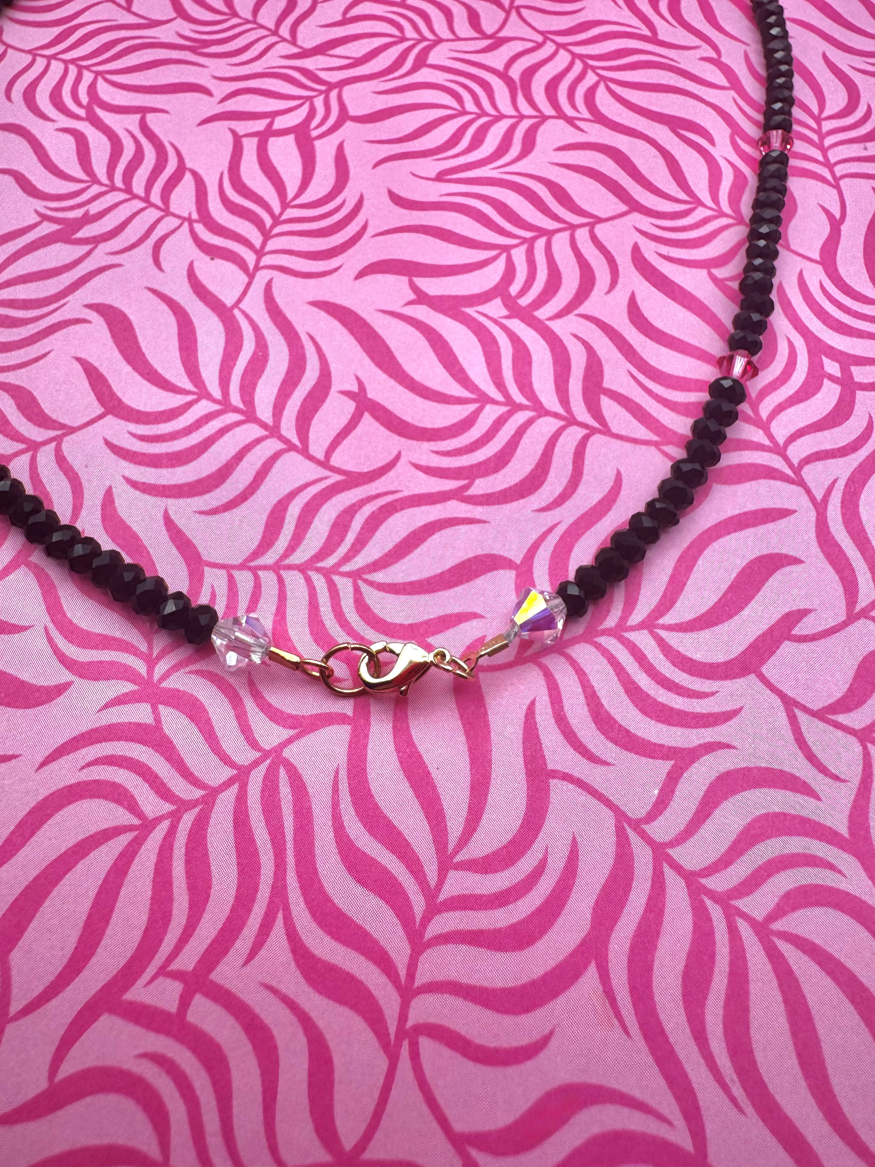 Collar hecho a mano con cuentas negras y rosas y gatito blanco.